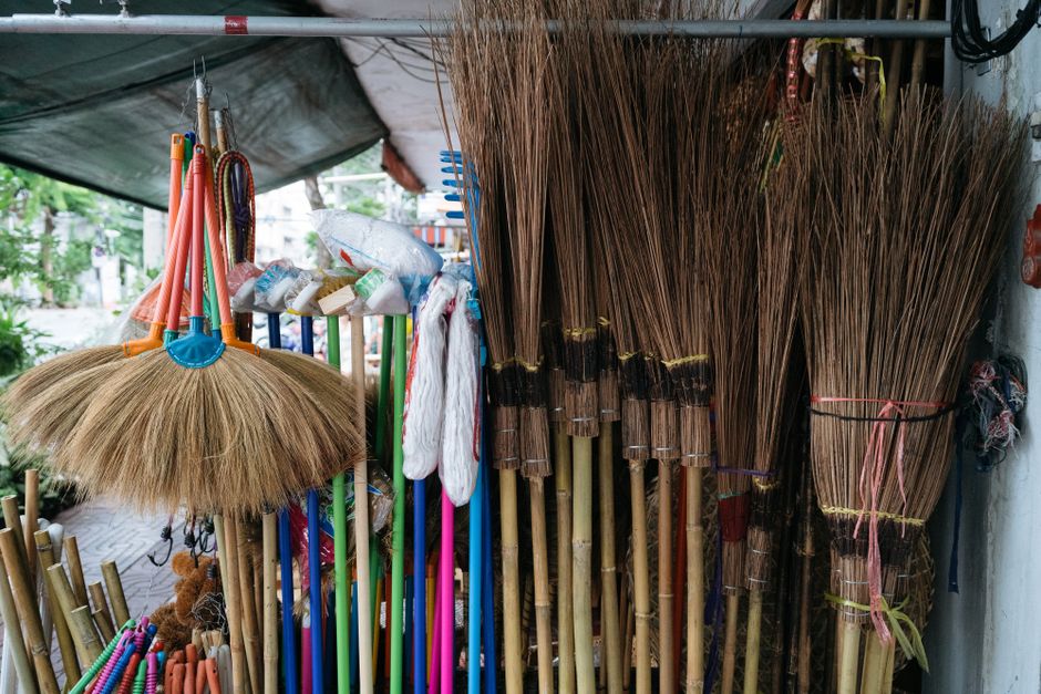 Colorful traditional brooms displayed outdoors, showcasing craftsmanship and culture.