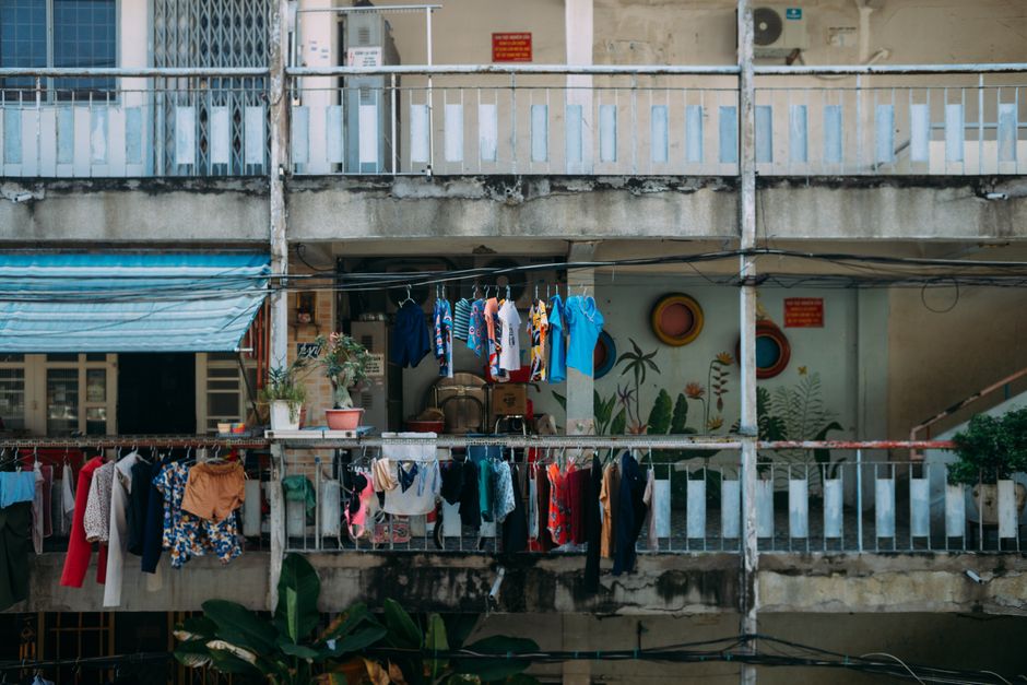 Vibrant clothes drying outside an urban apartment balcony, showcasing daily life.