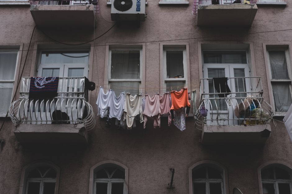 City apartment building with balconies and clothes drying outdoors. Captures urban residential life.